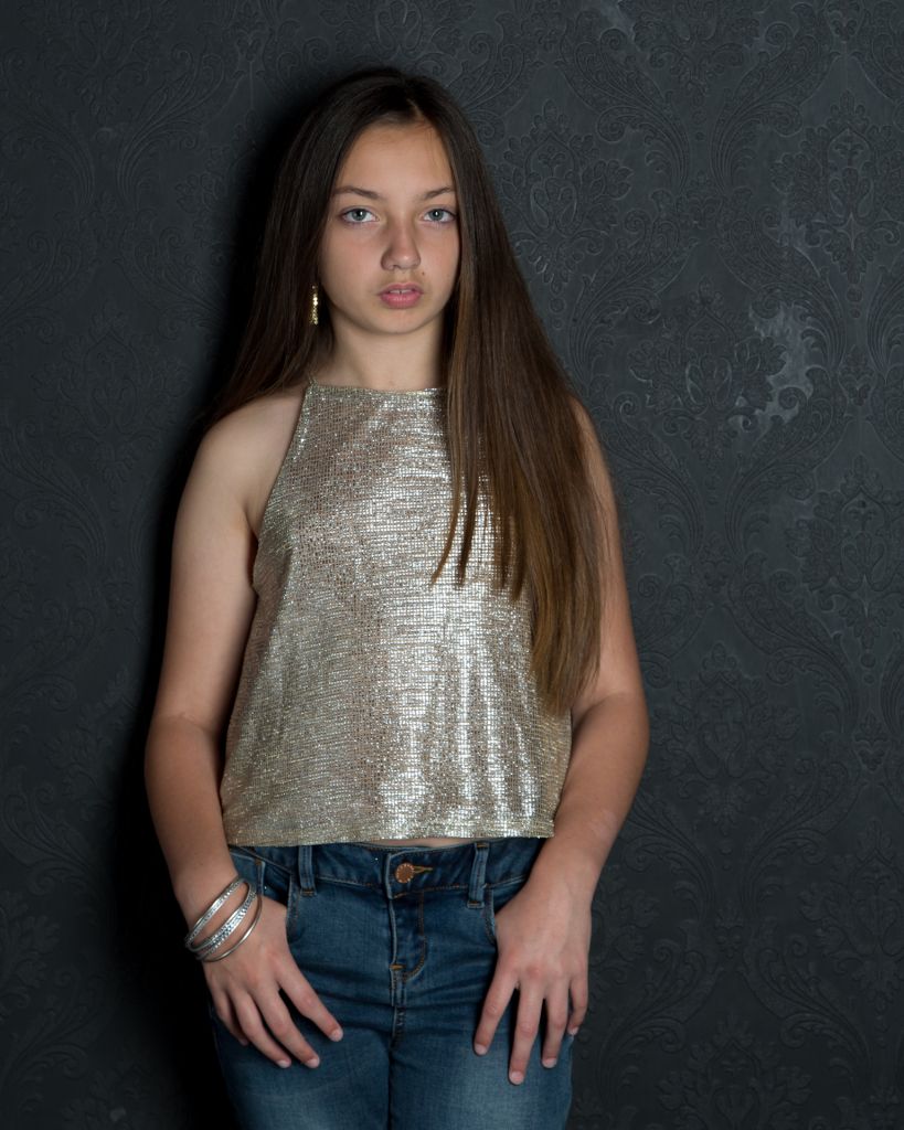 A picture of a child in a sparkly top and jeans