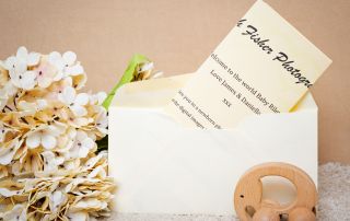 A gift voucher for a photo shoot styled with cream flowers and a small toy