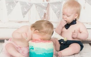 twins - the girl with her face buried in the cake and the boy taking a more cautious approach