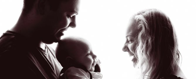 a backlit black and white image of a family smiling