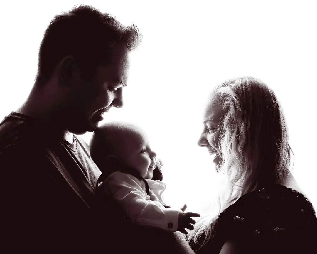 a backlit black and white image of a family smiling
