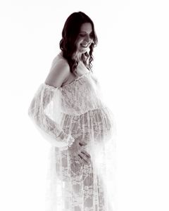 a pregnant woman wearing a white lace dress at a professional maternity portrait shoot
