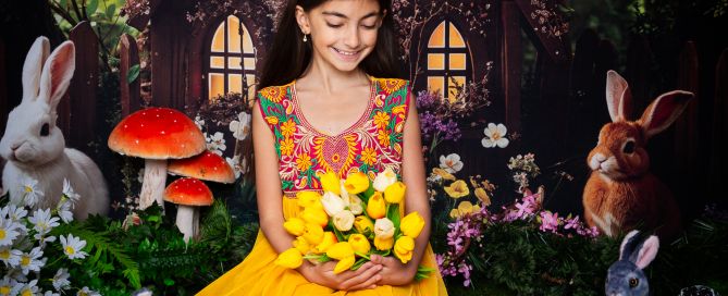 a girl poses in a yellow dress at an easter mini shoot