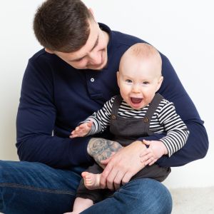 A dad and his young son pose together a professional photo shoot