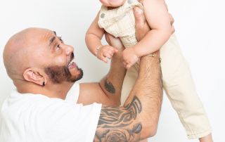 A dad flying his baby boy up into the air