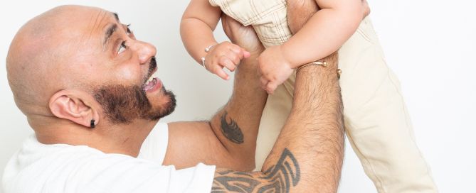 A dad flying his baby boy up into the air