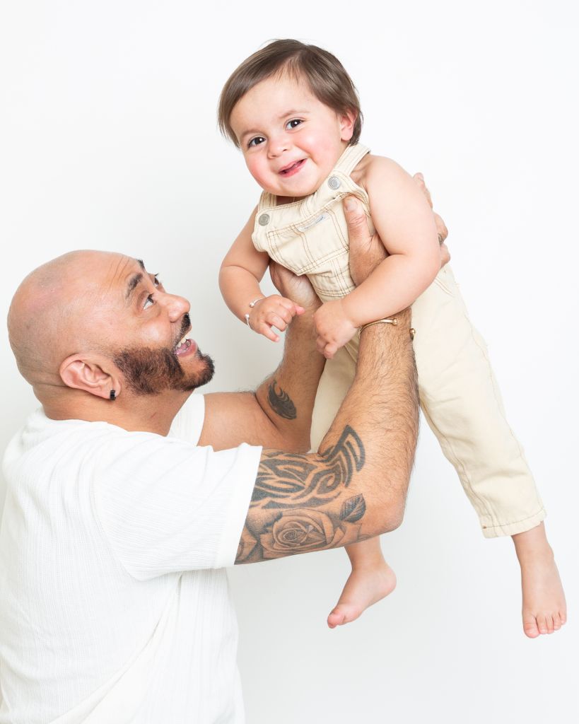A dad flying his baby boy up into the air
