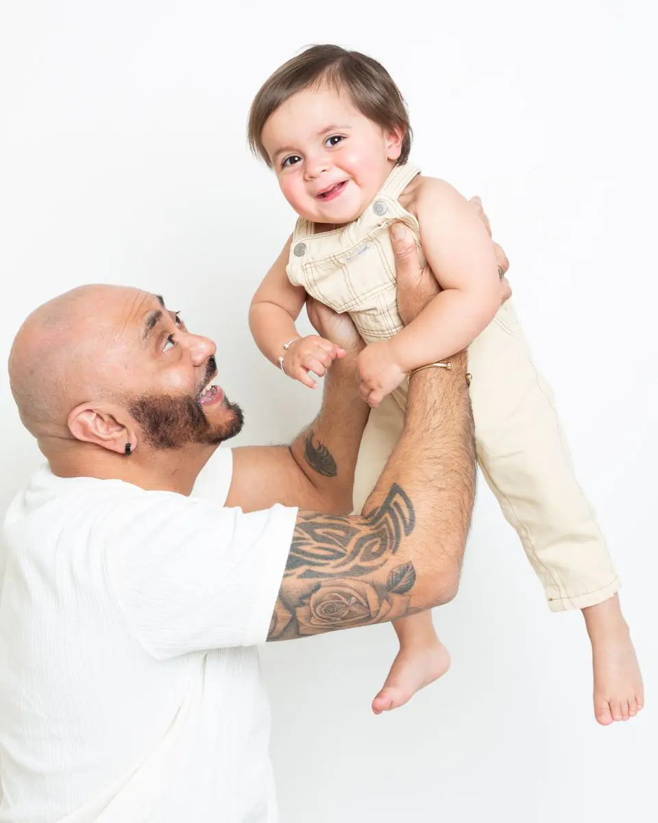 A dad flying his baby boy up into the air