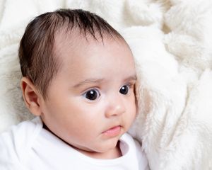 a tiny baby is lying on a blanket with wide open eyes