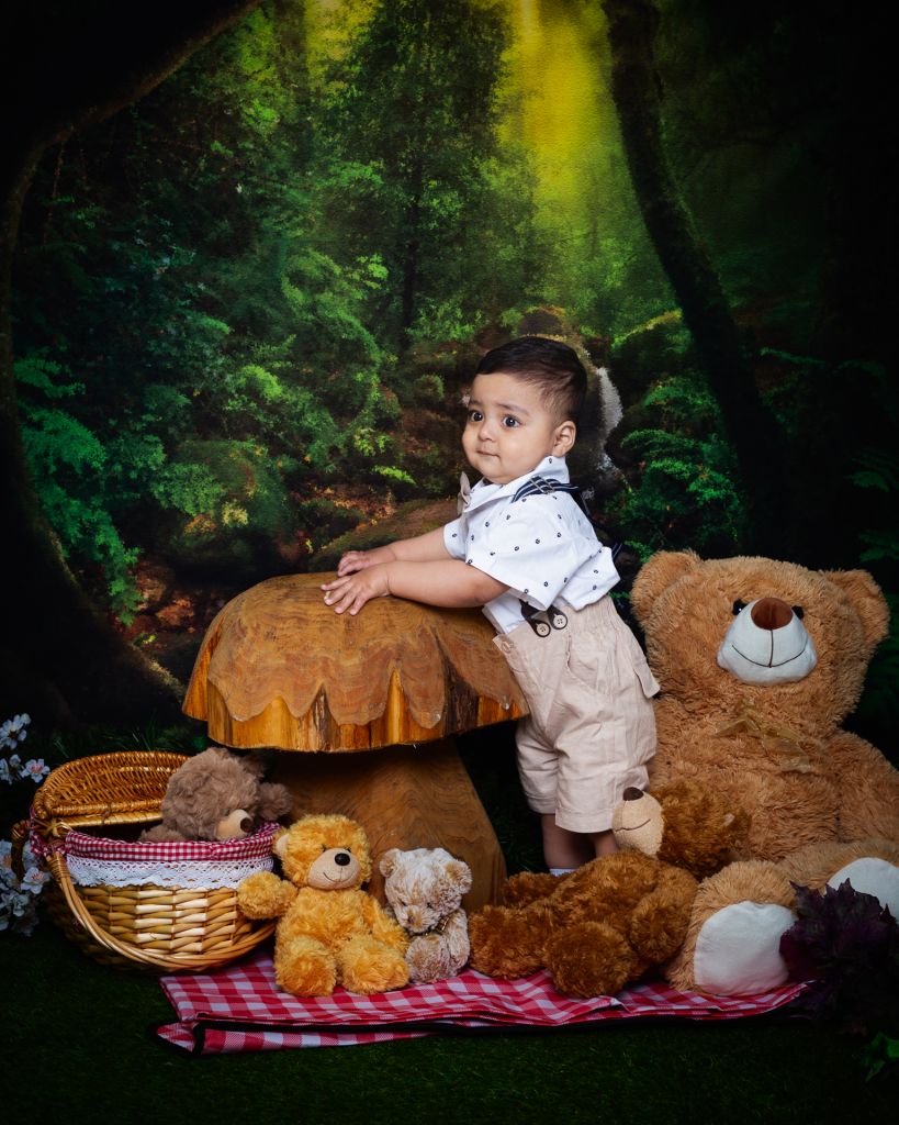 Baby Photography East Grinstead West Sussex a little boy poses in a woodland set up surrounded by tedeies having a picnic