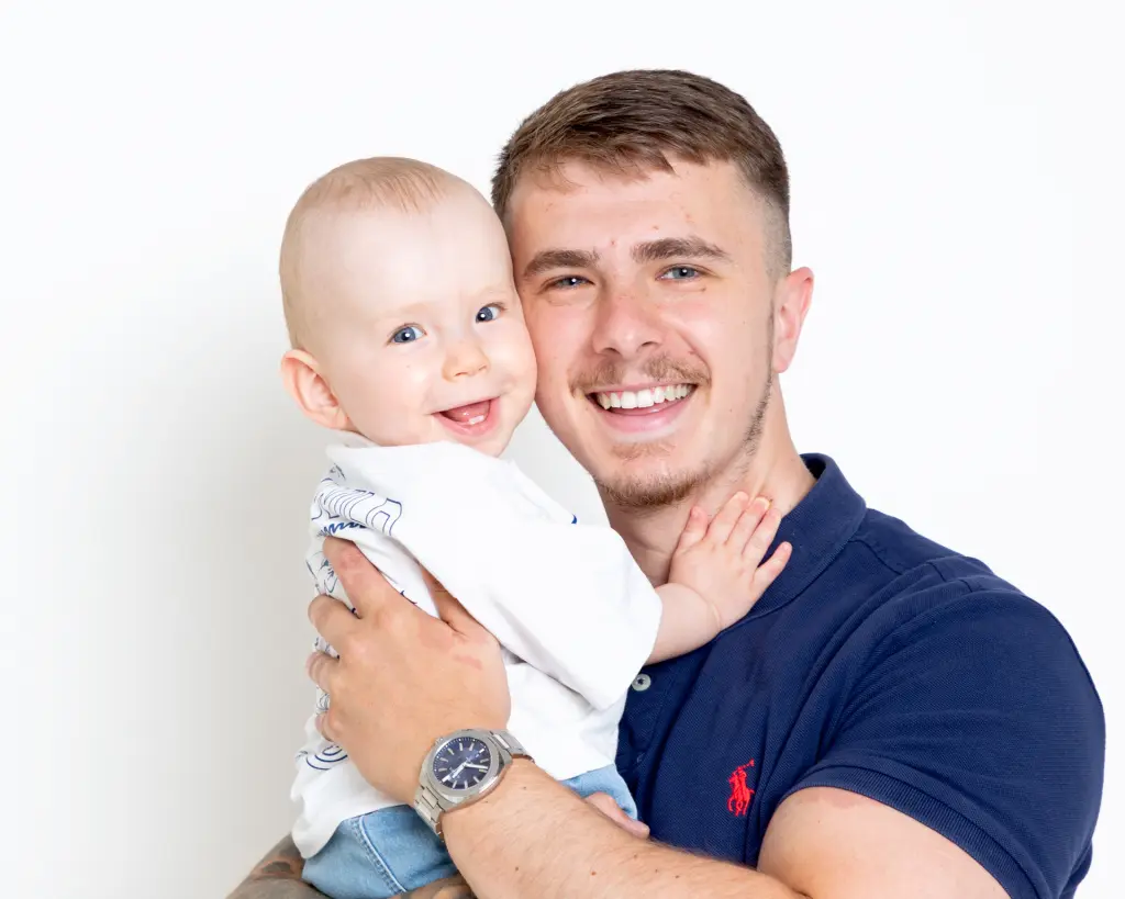 Family Portrait Photo Shoot East Grinstead West Sussex a dad and his baby son are photographed in the studio both smiling cheeks pressed together