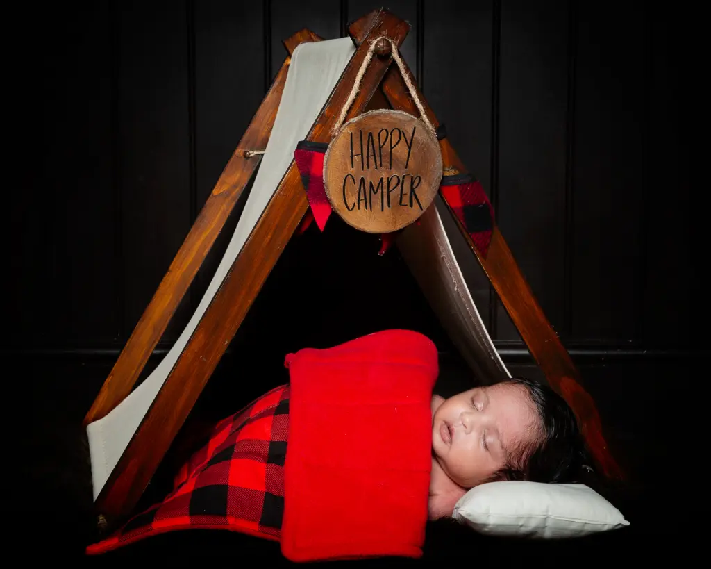 Newborn Photography East Grinstead West Sussex A newborn baby sleeps under a miniature camping tent
