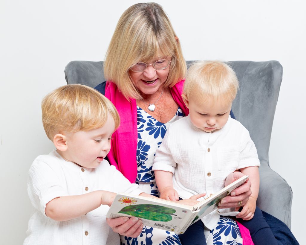 A grandmother reads the hungry caterpillar to her grandsons