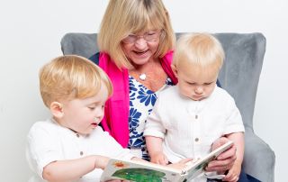 A grandmother reads the hungry caterpillar to her grandsons