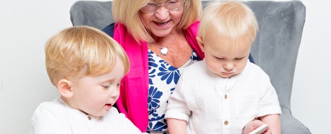A grandmother reads the hungry caterpillar to her grandsons
