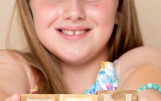 a little girl holds blocks that read ten...