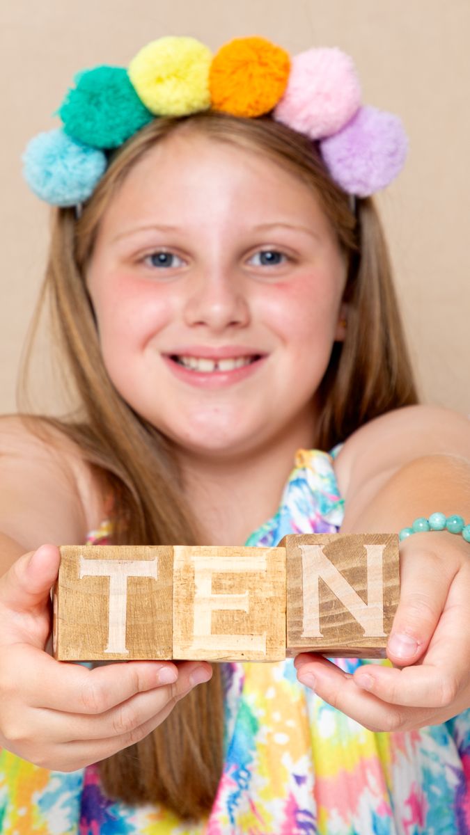 a little girl holds blocks that read ten...