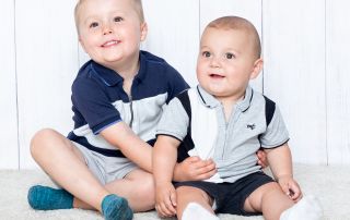 Two brothers pose together in a photo shoot in similar blue thsirts