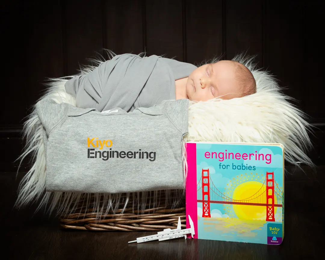 A baby sleeps by a branded tshirt for an engineering company his parents work for.