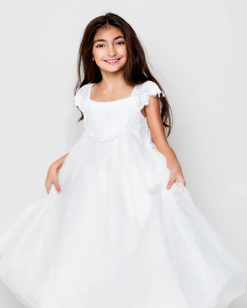 a girl plays with a white dress at west sussex fine art children's photography session