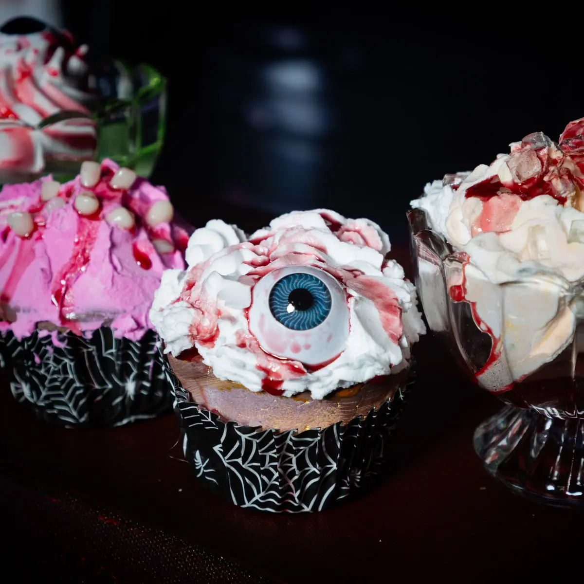 A cupcake with a bloody eyeball decoration