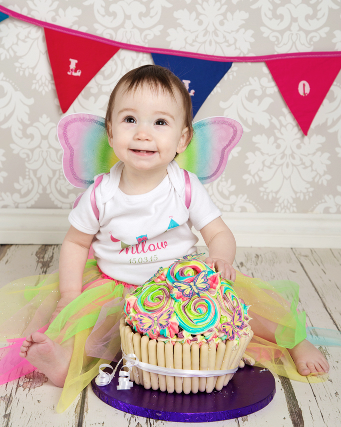 Baby Photography West Sussex A baby in a rainbow outfit at a cake smash photo shoot