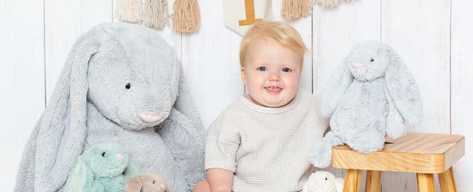 a little boy at a photo shoot with a bunch of bunny toys