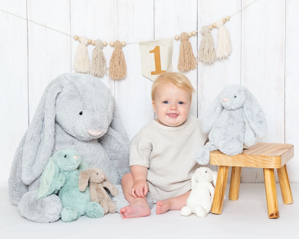a little boy at a photo shoot with a bunch of bunny toys