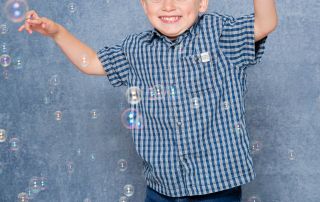 a little boy plays in the bubbles at my studio