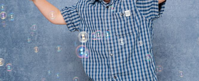 a little boy plays in the bubbles at my studio