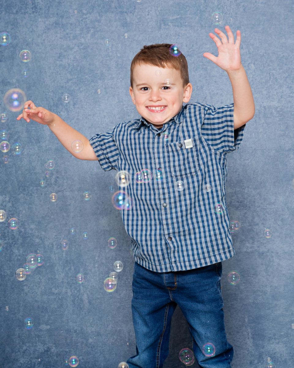 a little boy plays in the bubbles at my studio