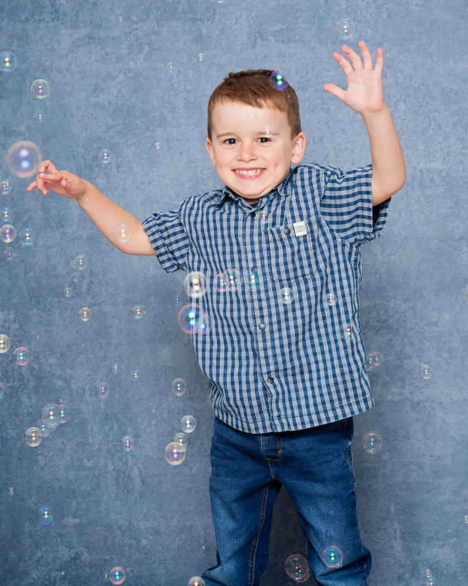 a little boy plays in the bubbles at my studio