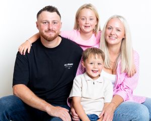 A family pose together in pink and black outfits