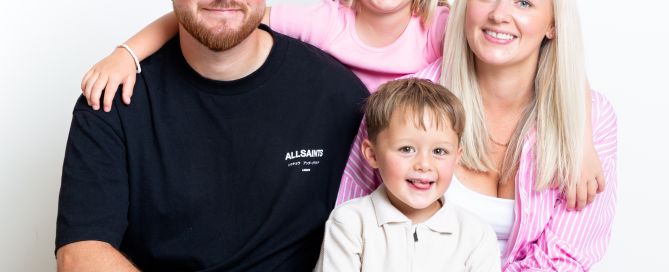 A family pose together in pink and black outfits