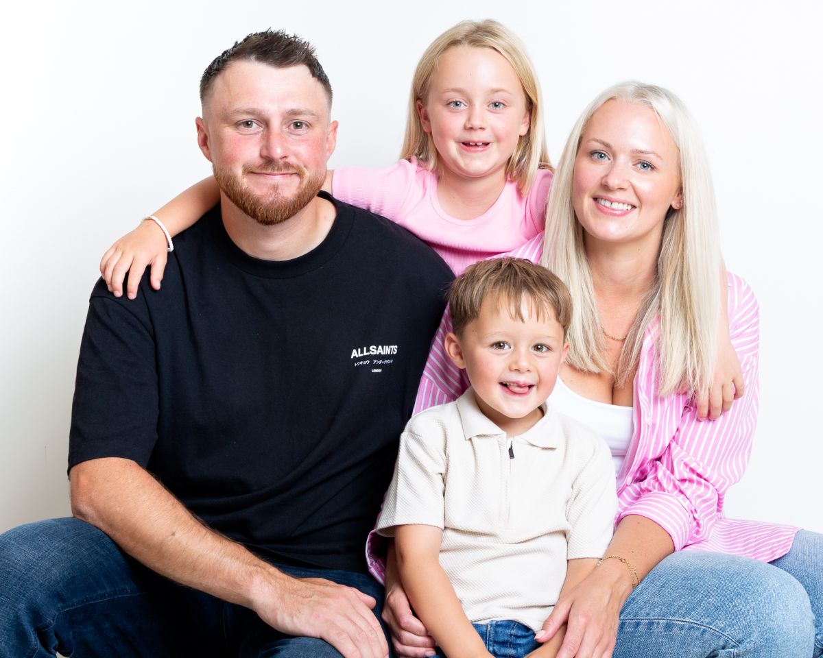 A family pose together in pink and black outfits