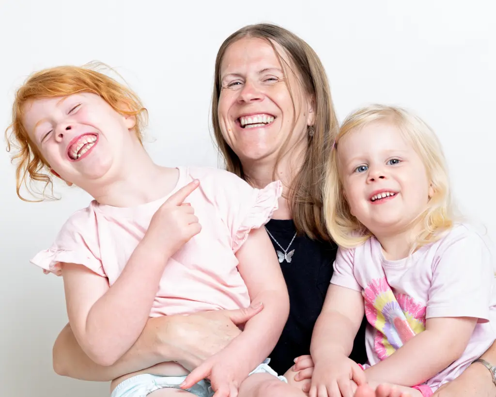 Family Portrait Photo Shoot East Grinstead West Sussex a mother and her two daughters laugh a family portrait session