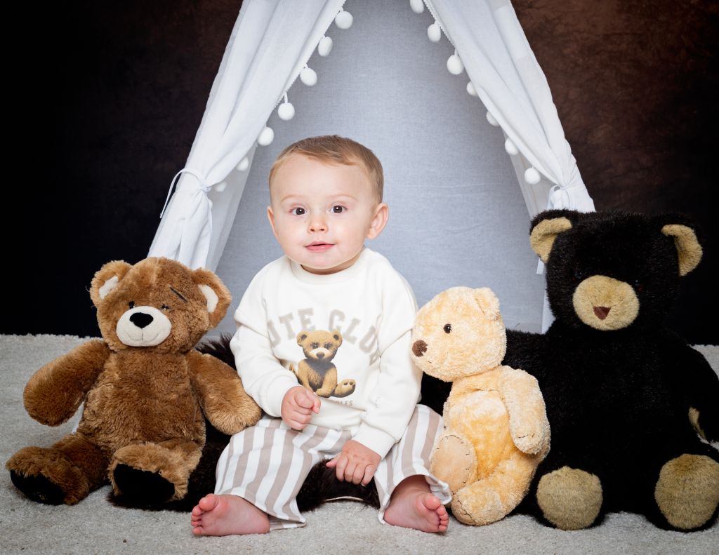Baby Photography East Grinstead West Sussex a little boy poses with teddy bears in a matching bear jumper