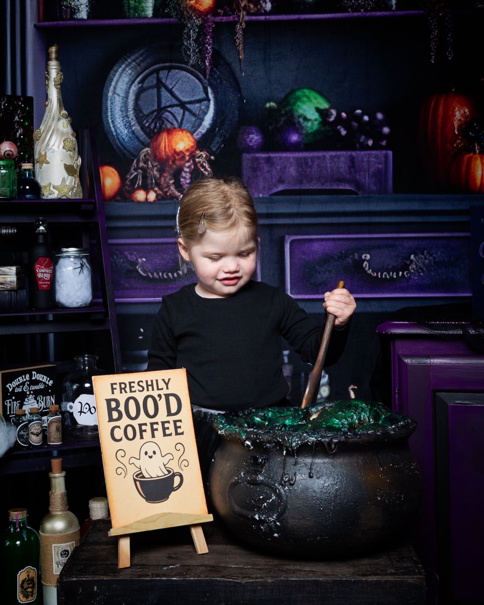 a little girl stirs a cauldron at a halloween photo shoot in west sussex