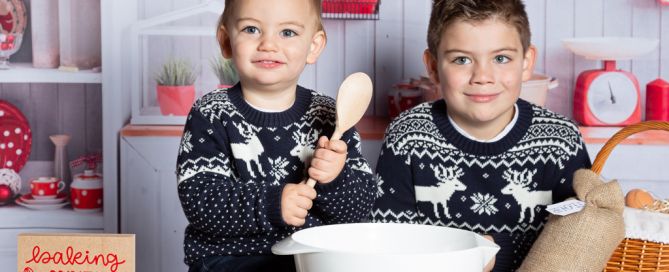 two brother's pose in a Christmas themed kitchen set