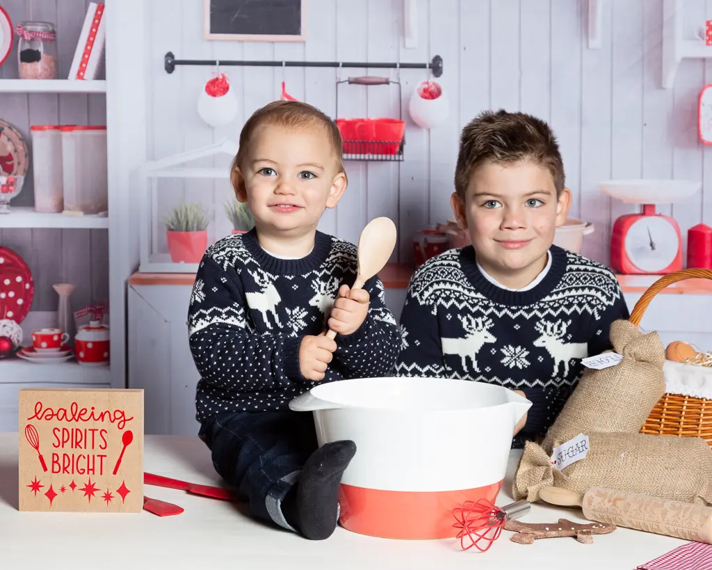 two brother's pose in a Christmas themed kitchen set