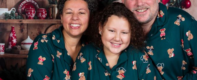 A family pose for a Christmas photo in matching pyjamas
