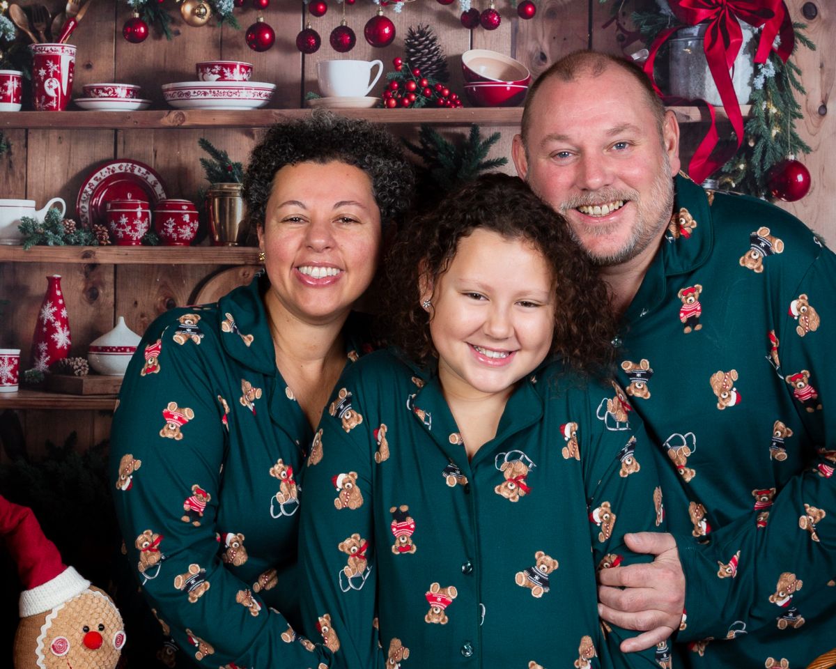 A family pose for a Christmas photo in matching pyjamas