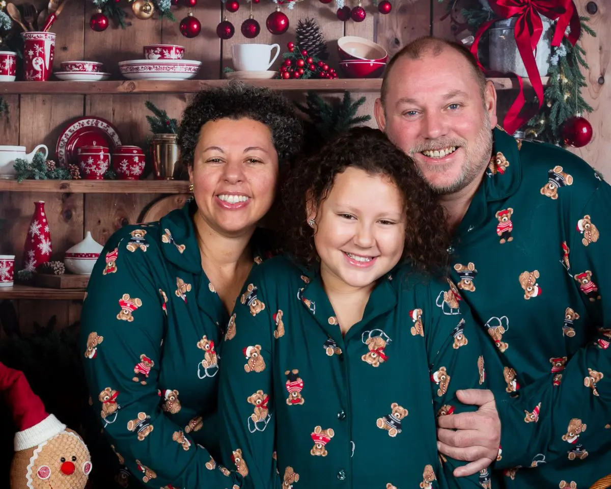 A family pose for a Christmas photo in matching pyjamas