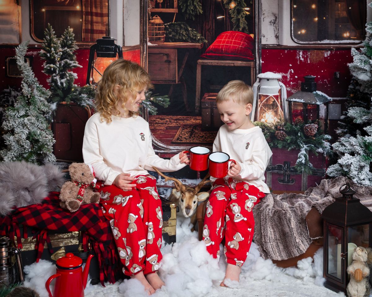 Christmas Photo Shoots West Sussex 2025 two children cheers their cups of hot chocolate in a camping themed Christmas set