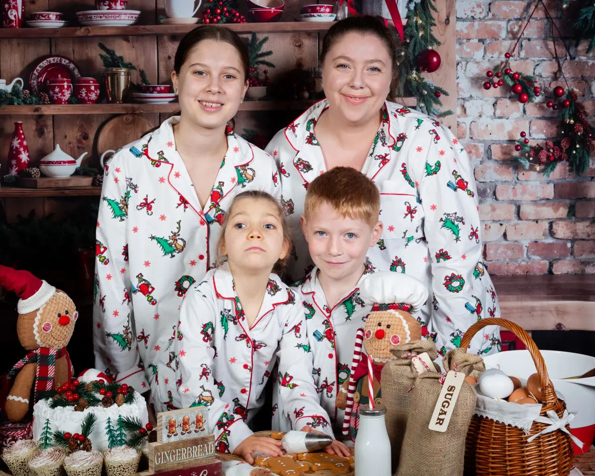 a family pose in matching white christmas pyjamas
