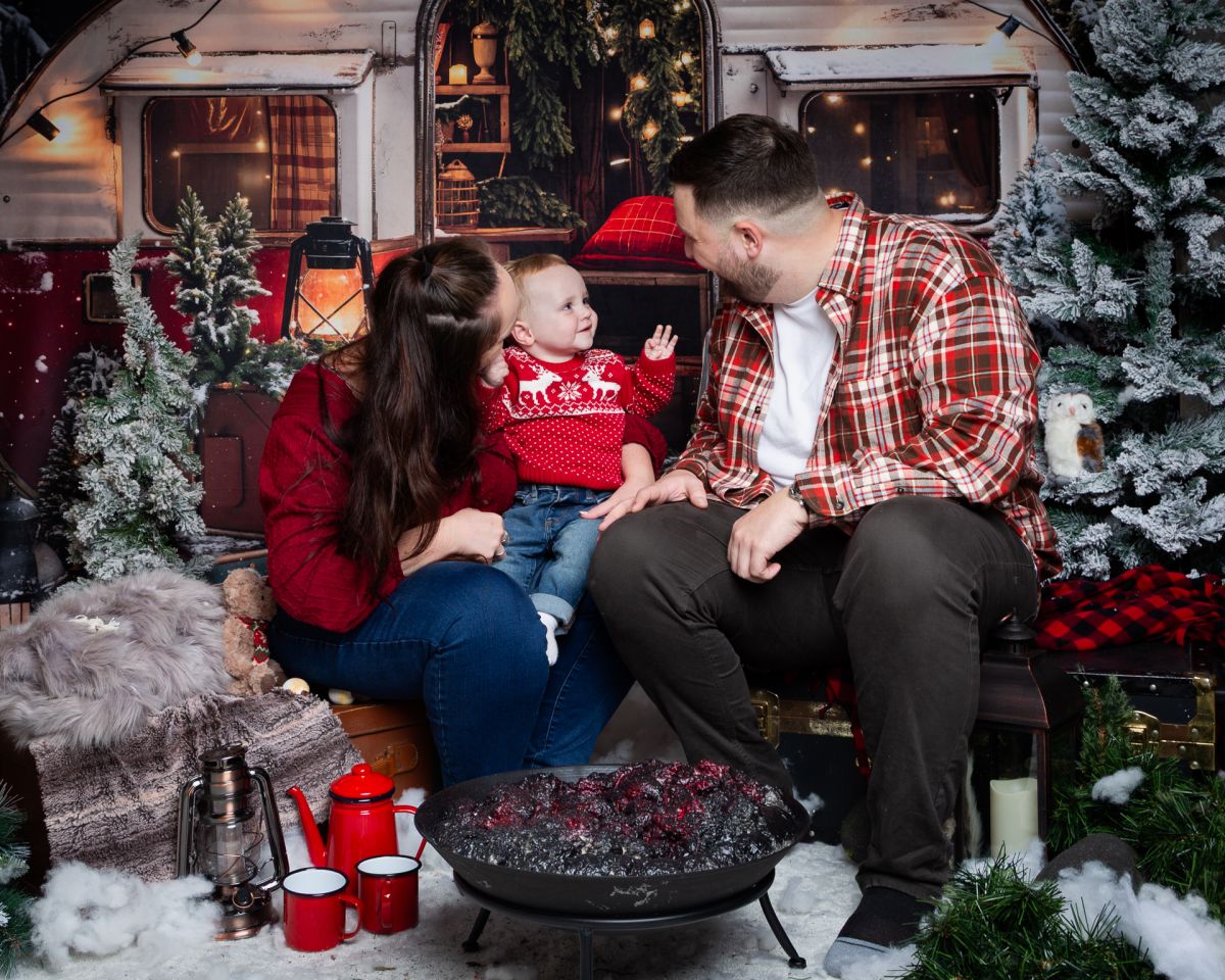 Christmas Photo Shoots West Sussex 2025 A family look at each other in a Christmas themed set