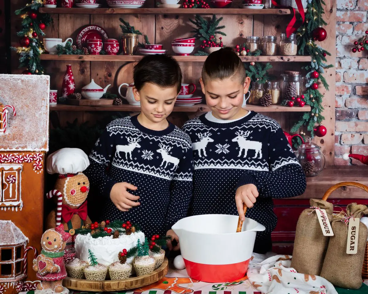 two brothers pose in a christmas kitchen themed set in matching jumpers