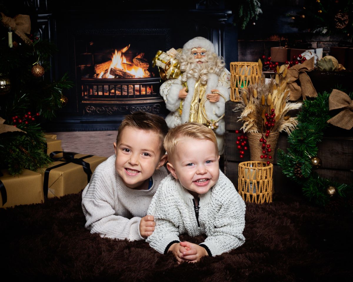 Christmas Photo Shoots West Sussex 2025 two brothers pose in a Fireside themed Christmas set