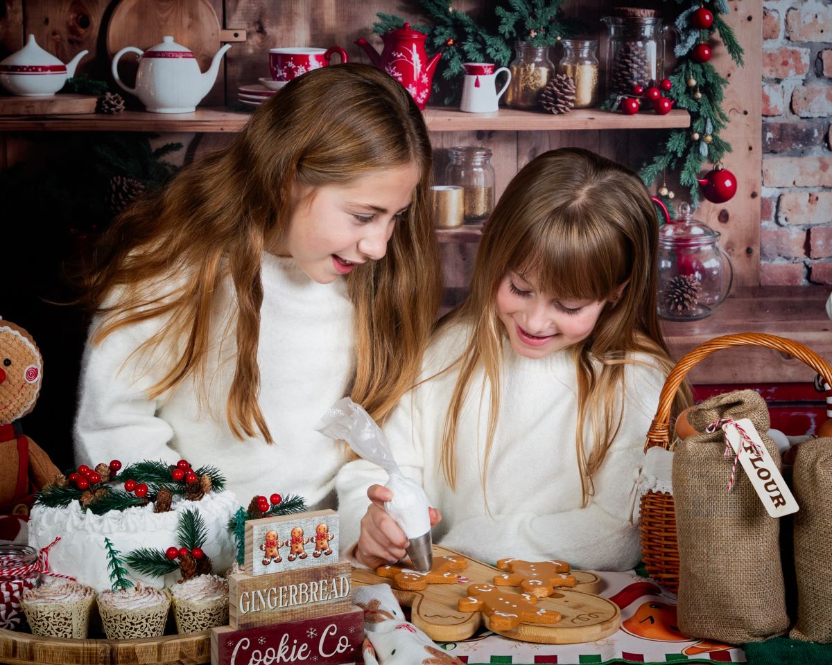 Christmas Photo Shoots West Sussex 2025 two sisters pretend to ice cakes in a photo shoot