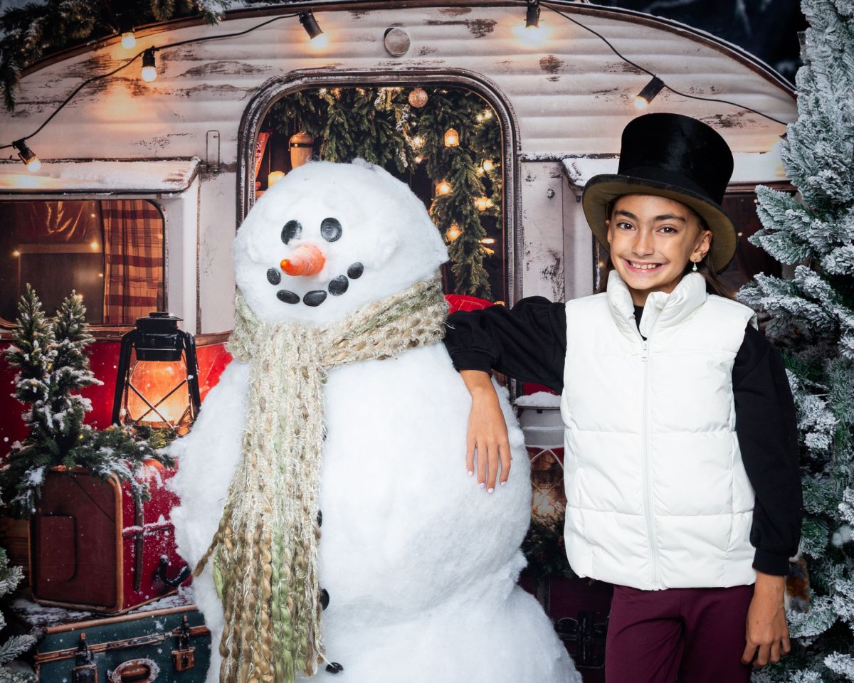 Christmas Photo Shoots West Sussex 2025 a girl poses with Frosty the giant snowman